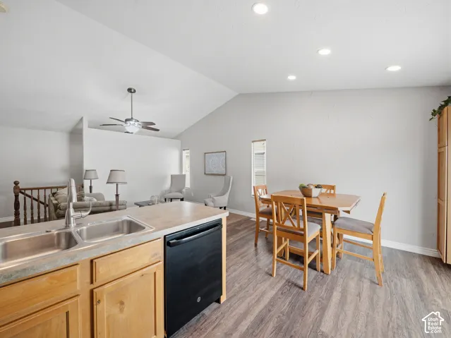 Kitchen with a double basin sink, wood-finish cabinetry, and black dishwasher