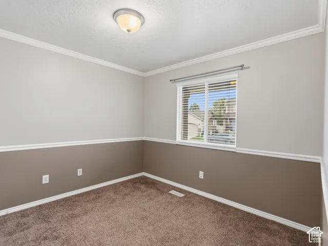 Neutral two-tone wall paint with crown molding and chair rail