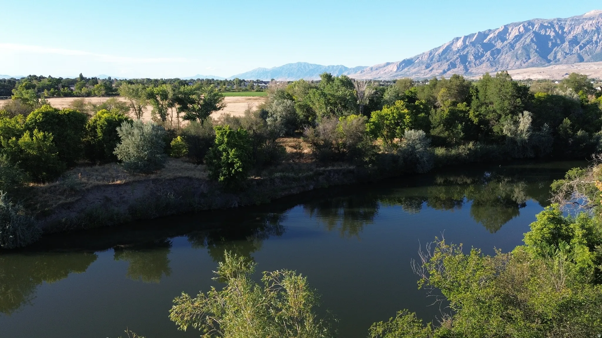 Riverfront setting with mature trees and mountain backdrop