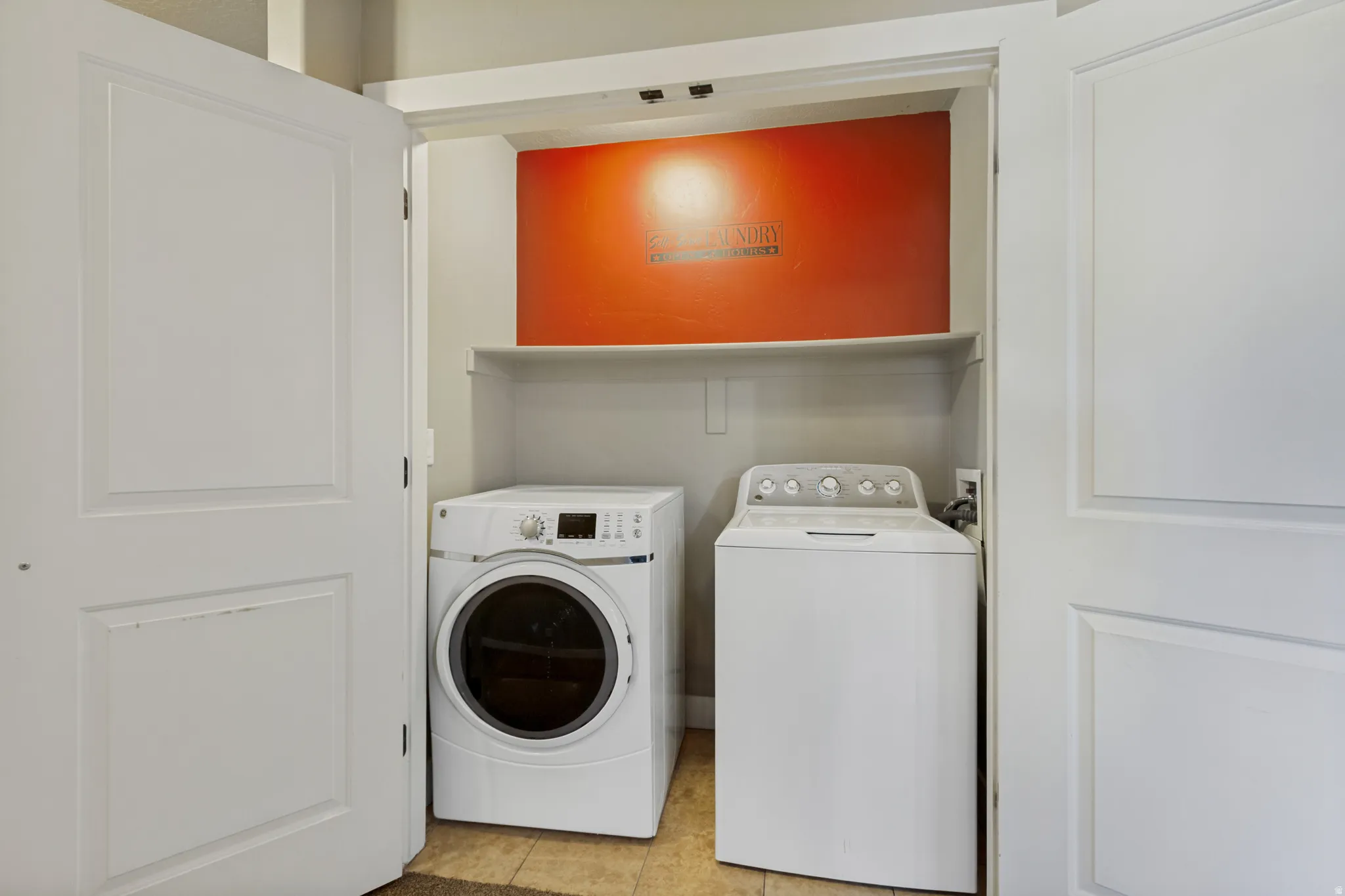 Utility closet featuring a built-in shelf and tile flooring