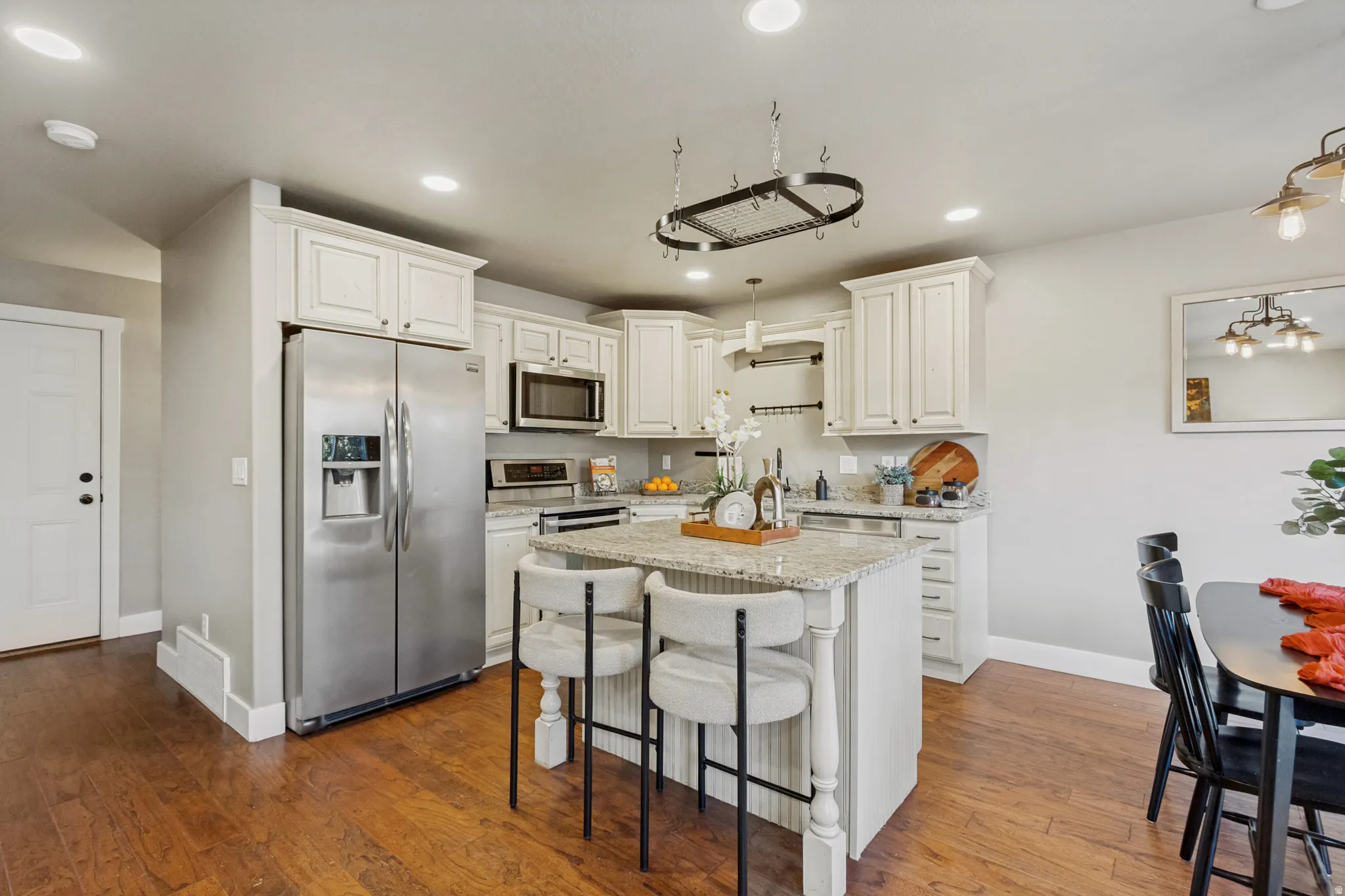 Kitchen featuring white cabinetry, stainless steel appliances, a center island and granite countertops