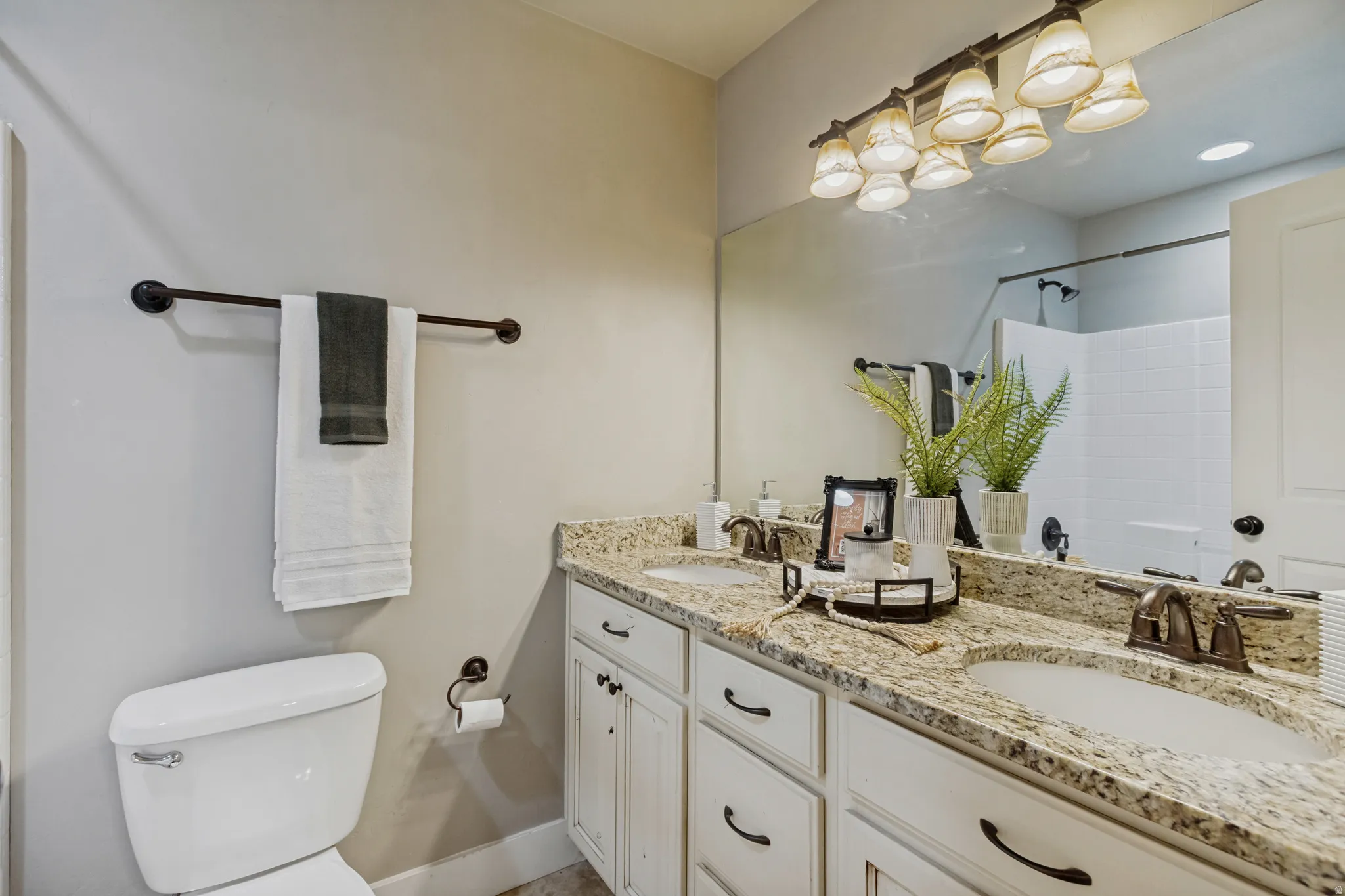 Dual vanity with undermount sinks, granite countertops, and white wood-finish cabinetry