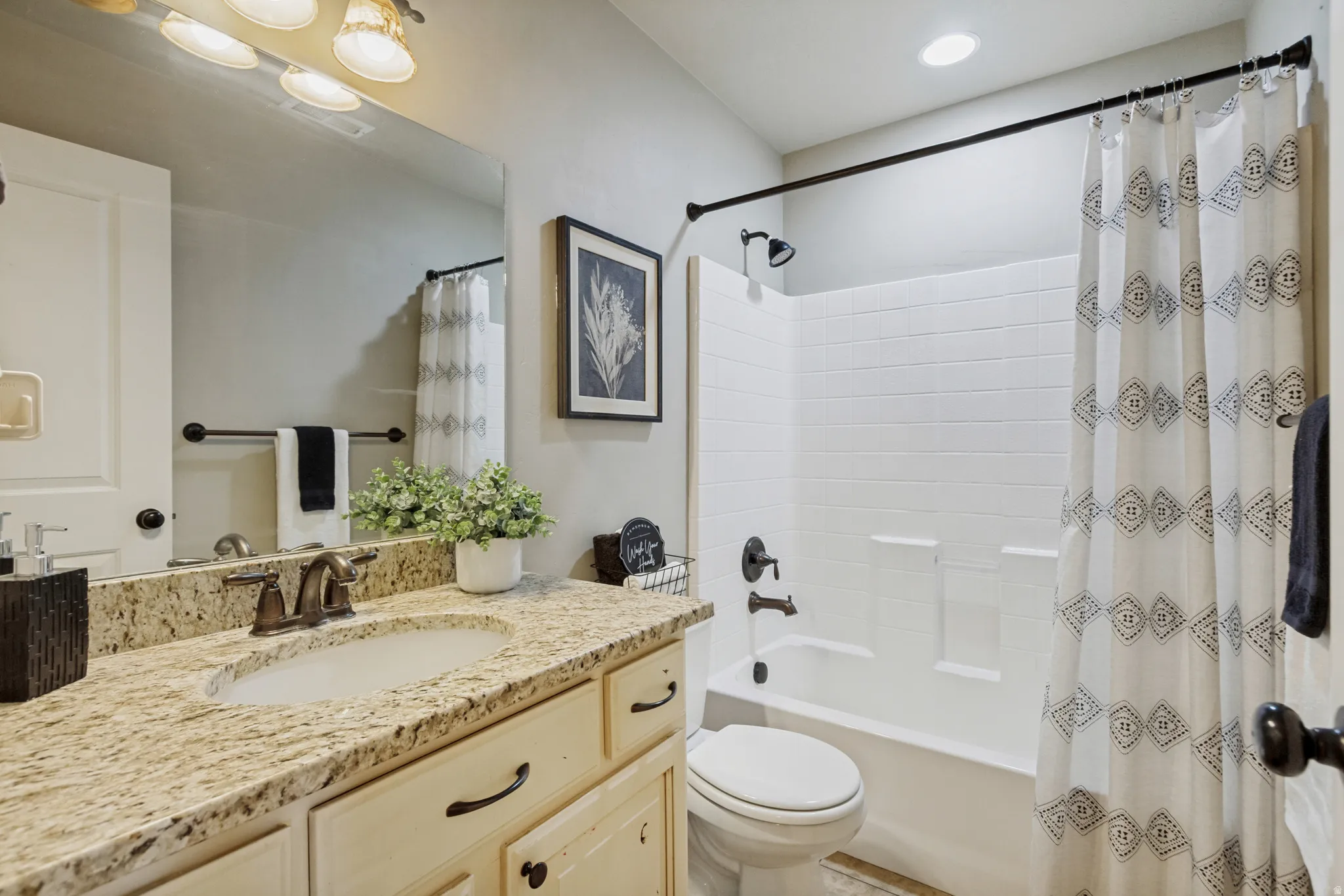 Bathroom vanity with an integrated sink, granite-style countertop, and a bronze-finish faucet