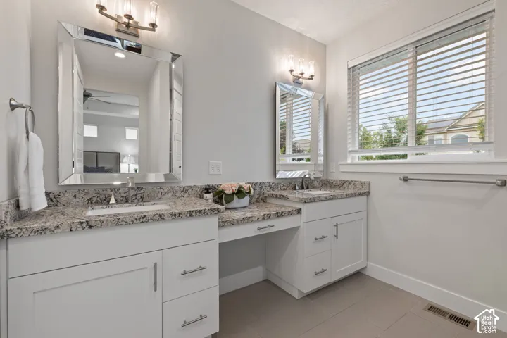 Dual vanity with light-toned countertops, white cabinetry, and undermount sinks