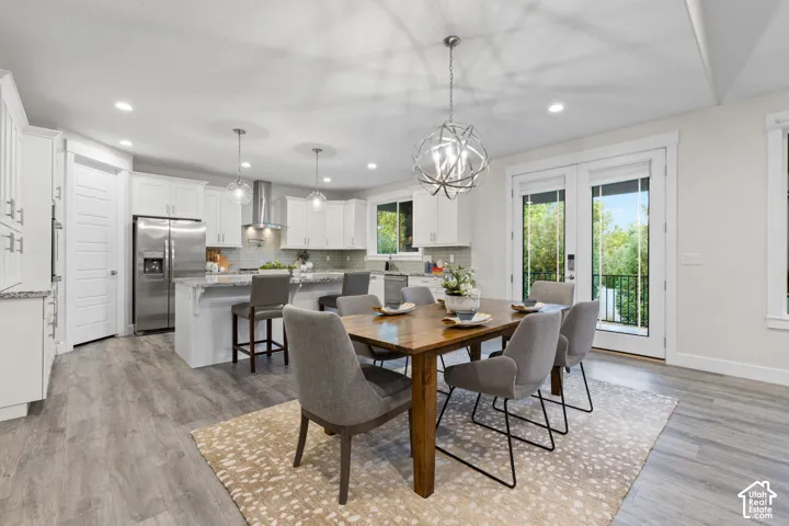 Modern kitchen featuring white cabinetry, stainless steel appliances, a center island with bar seating, and wood-finish flooring