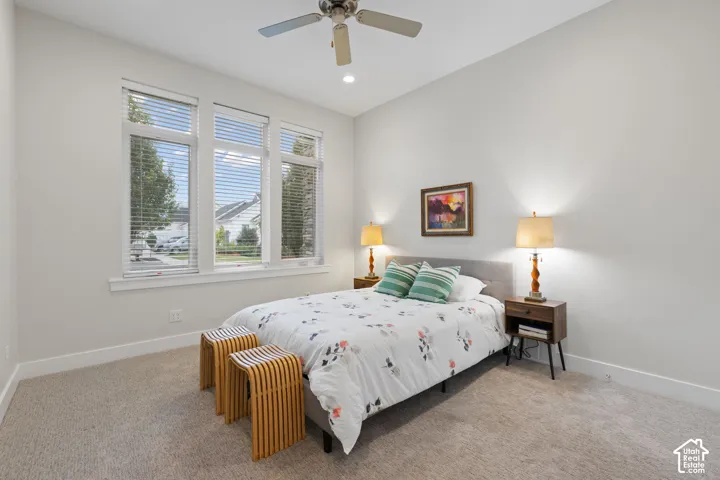 Multiple windows with blinds, recessed lighting, ceiling fan, and carpeted flooring