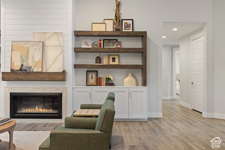 Shiplap accent wall with a wood mantel, stone fireplace surround, and built-in shelving