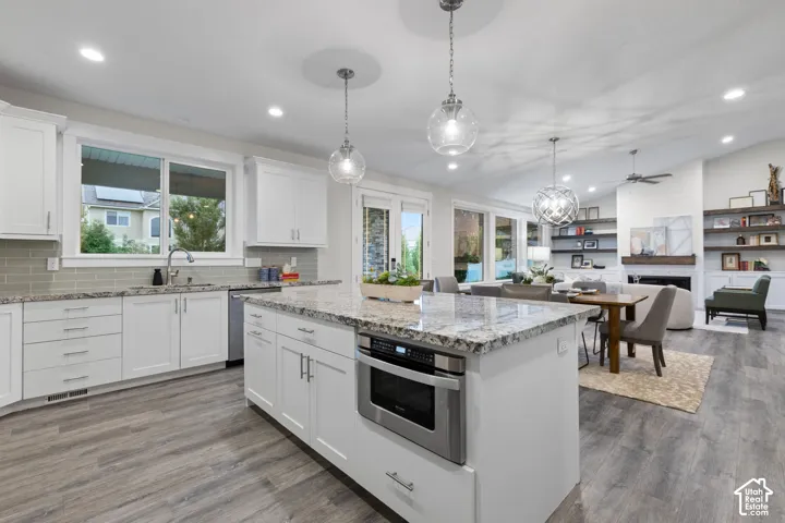 Kitchen with white cabinetry, stainless steel appliances, and a light-toned backsplash
