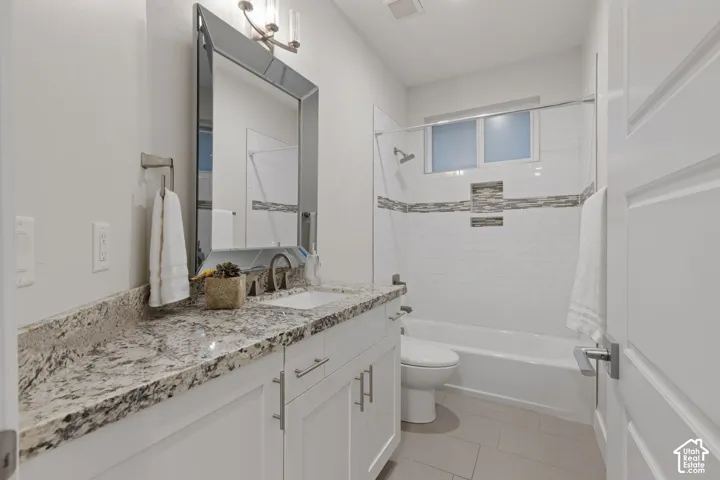 White vanity with brushed nickel hardware, granite countertop, undermount sink, and a framed mirror