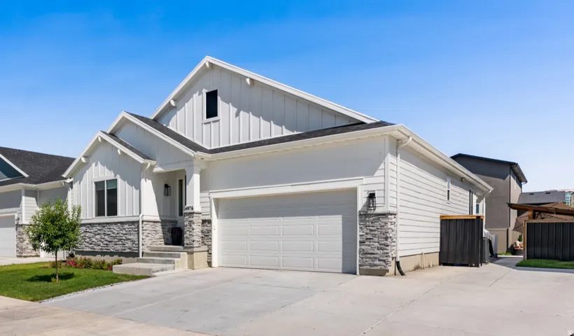 Exterior featuring board and batten siding, horizontal siding, stone facade, and an attached garage