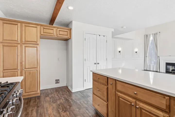 Wood-finish flooring with recessed lighting and exposed ceiling beam