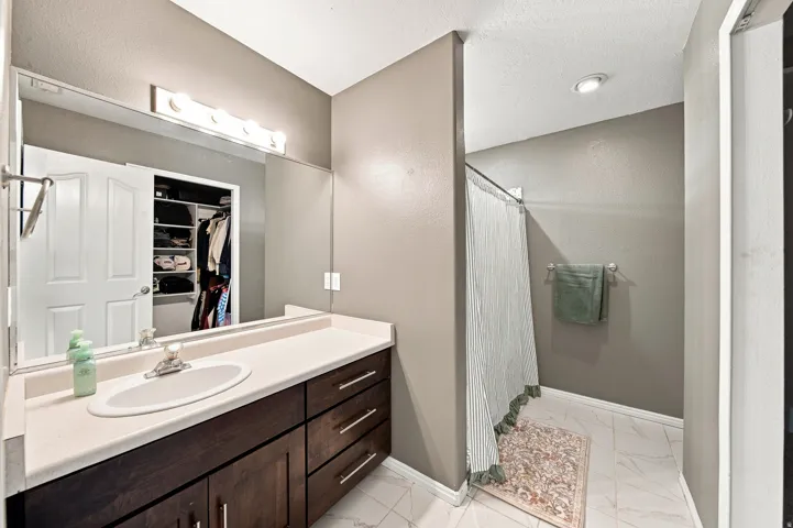 Wood-finish vanity with an integrated sink and light-colored countertop