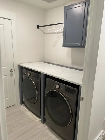 Built-in counter space with a solid surface, wall-mounted cabinetry, and a clothes hanging rod