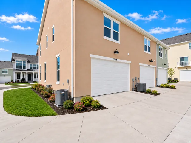 Stucco exterior with multiple white garage doors