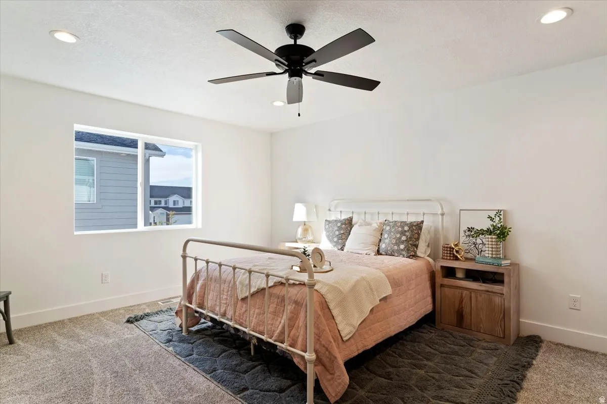 Recessed ceiling lighting, ceiling fan with light, white painted walls, and light-toned carpeting