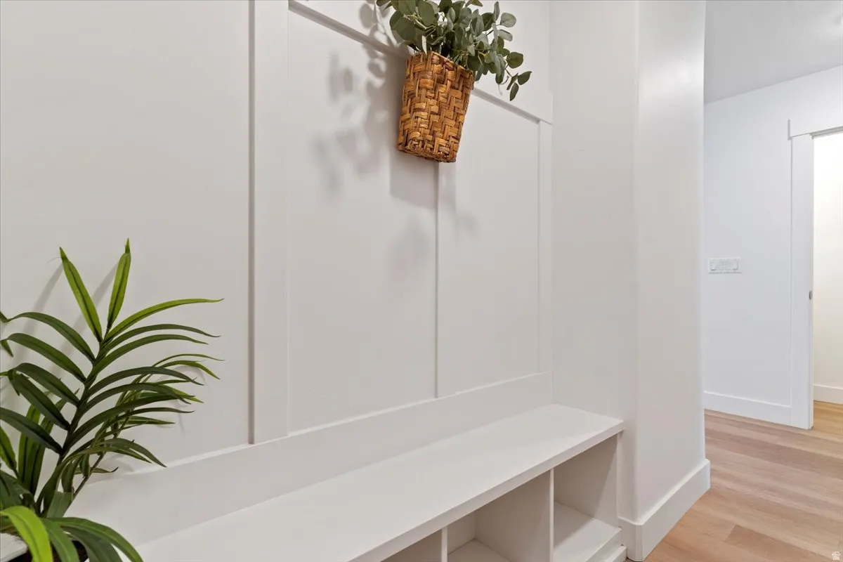 Built-in storage bench with cubbies, board and batten wall detailing, and light wood-finish flooring