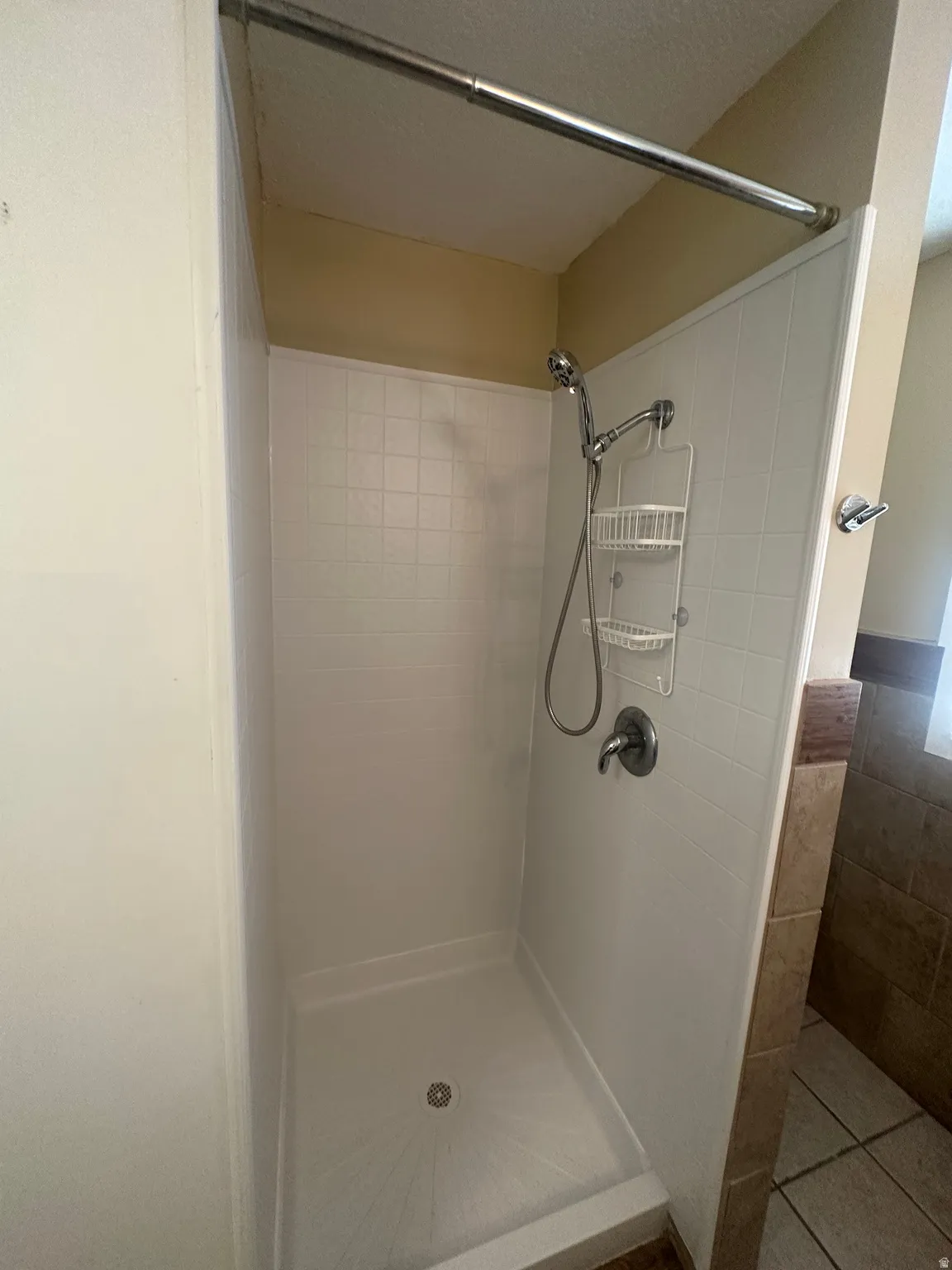 Shower stall with white wall panels and integrated shower base