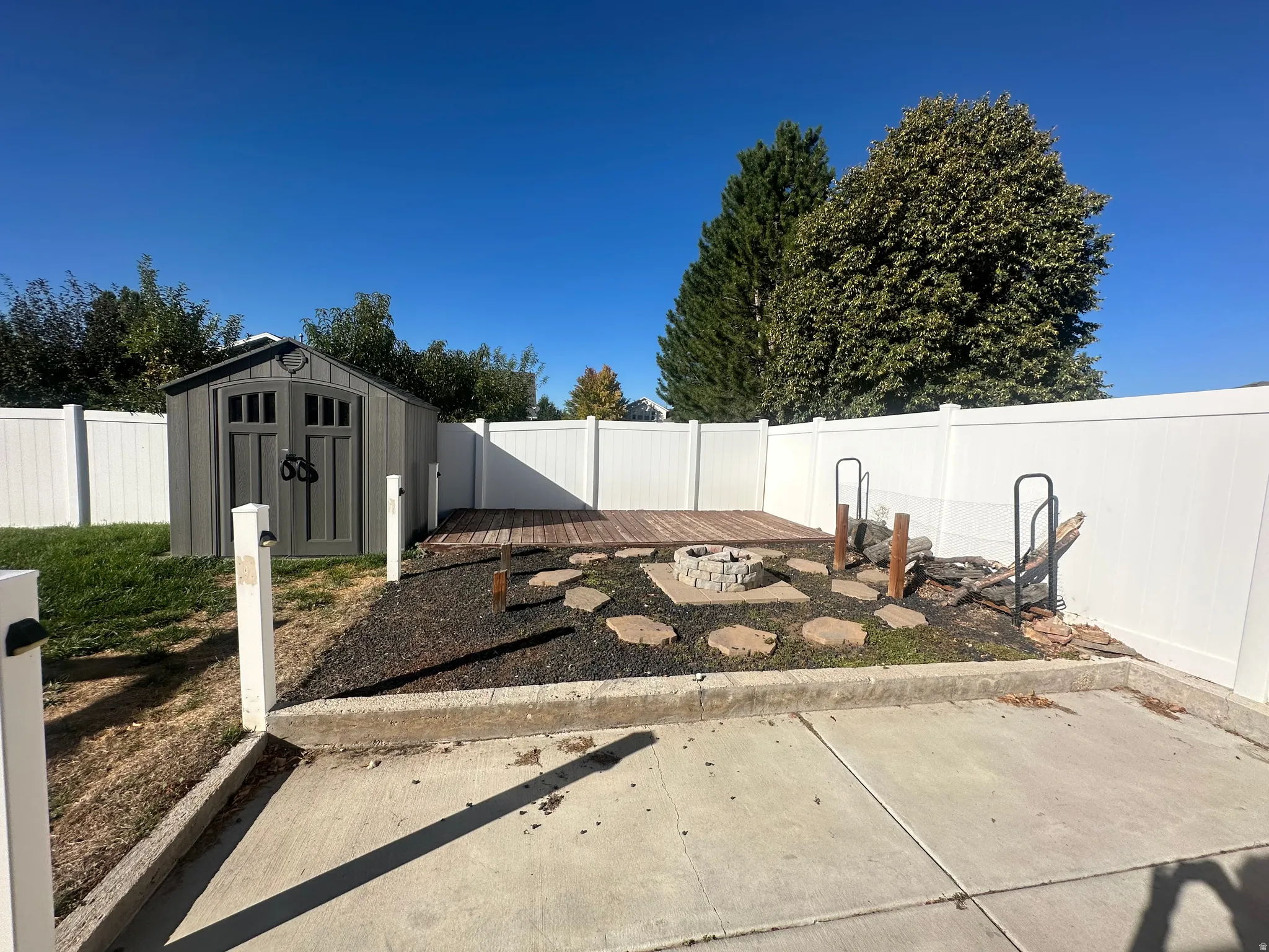 Paved patio area, composite decking, built-in fire pit, stone stepping paths, and a privacy fence