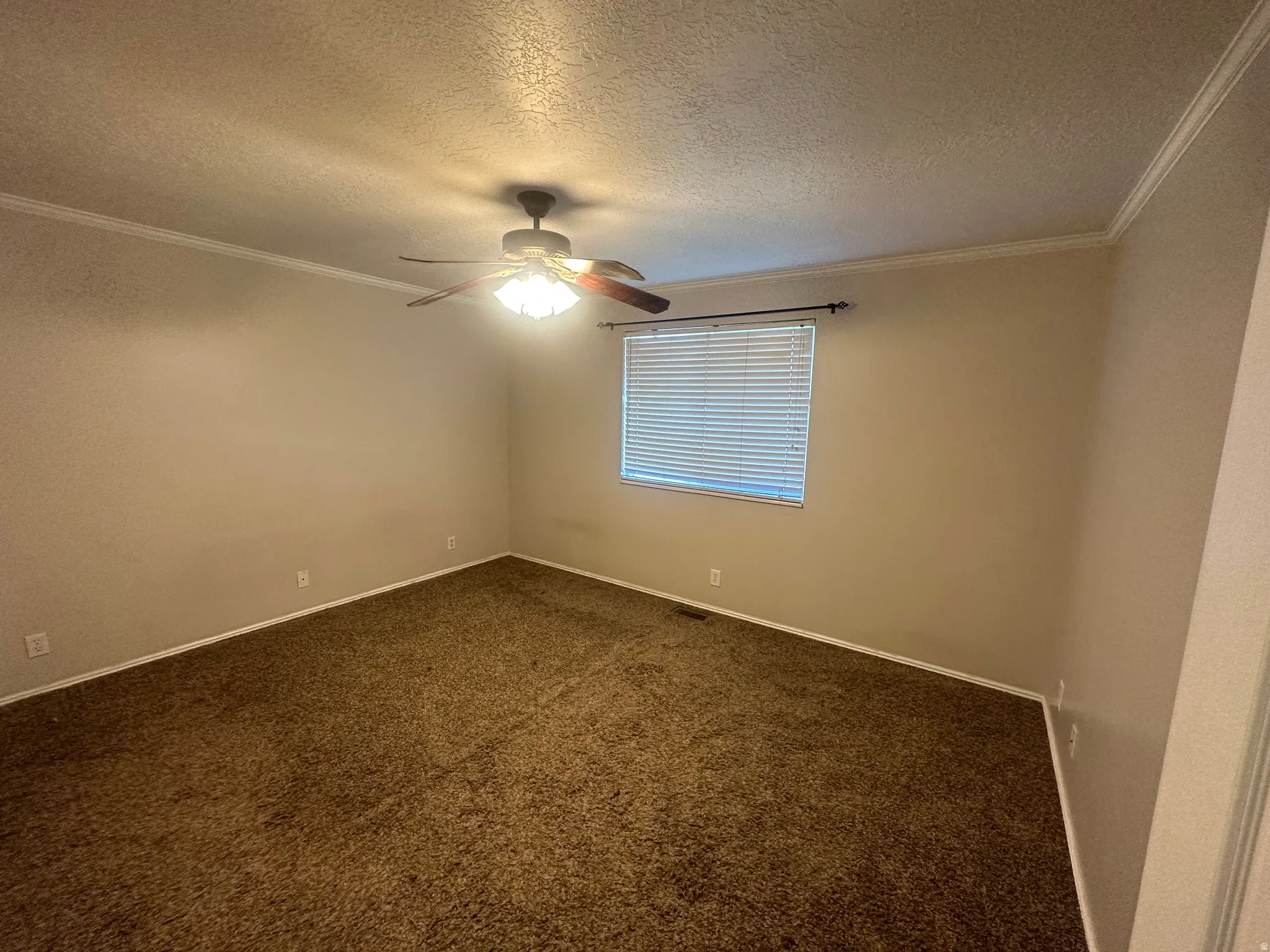 Ceiling fan with integrated lighting, window with blinds, crown molding, and neutral wall paint