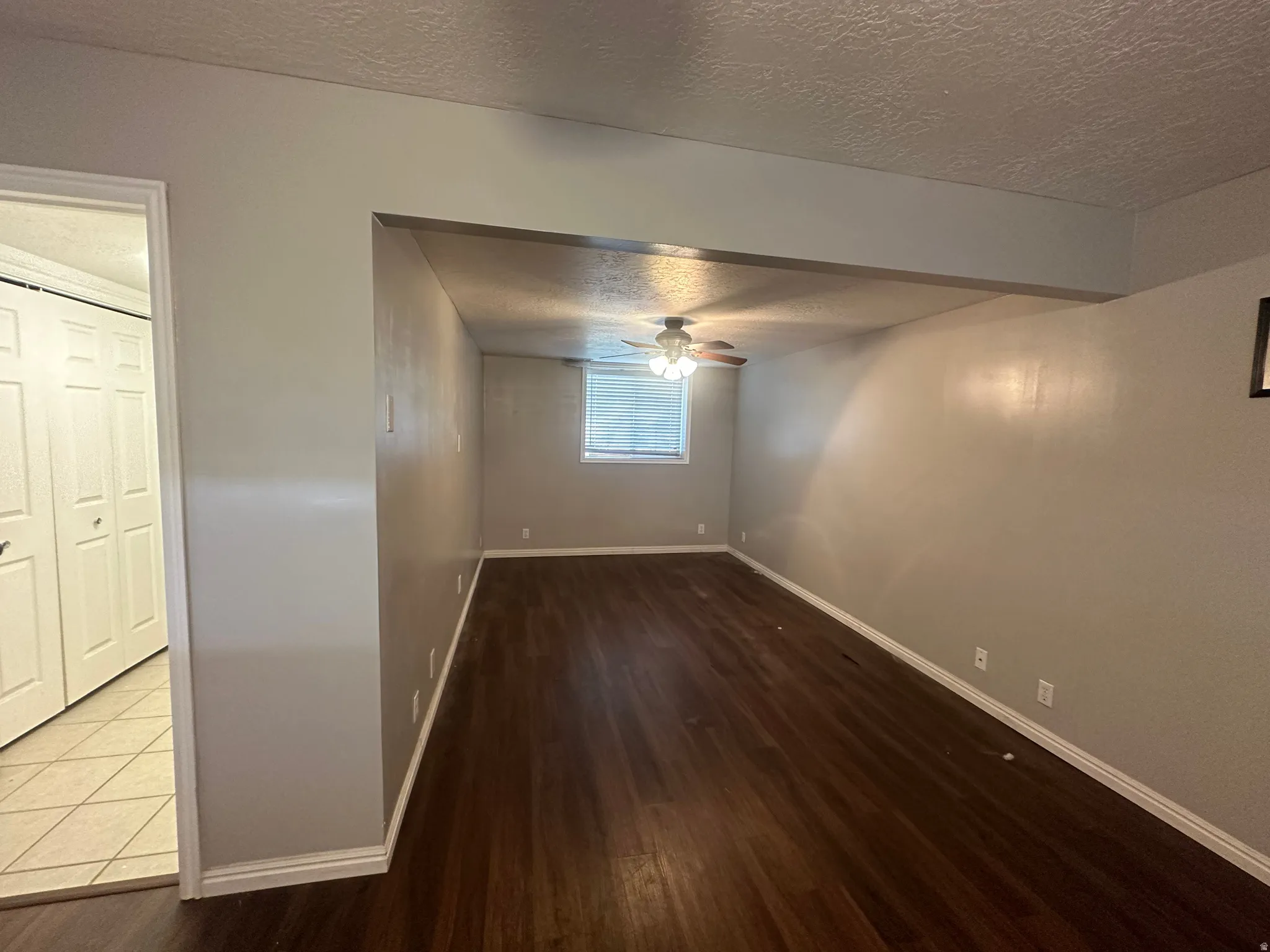 Wood-finish flooring throughout, neutral wall tones, and a ceiling fan with integrated lighting