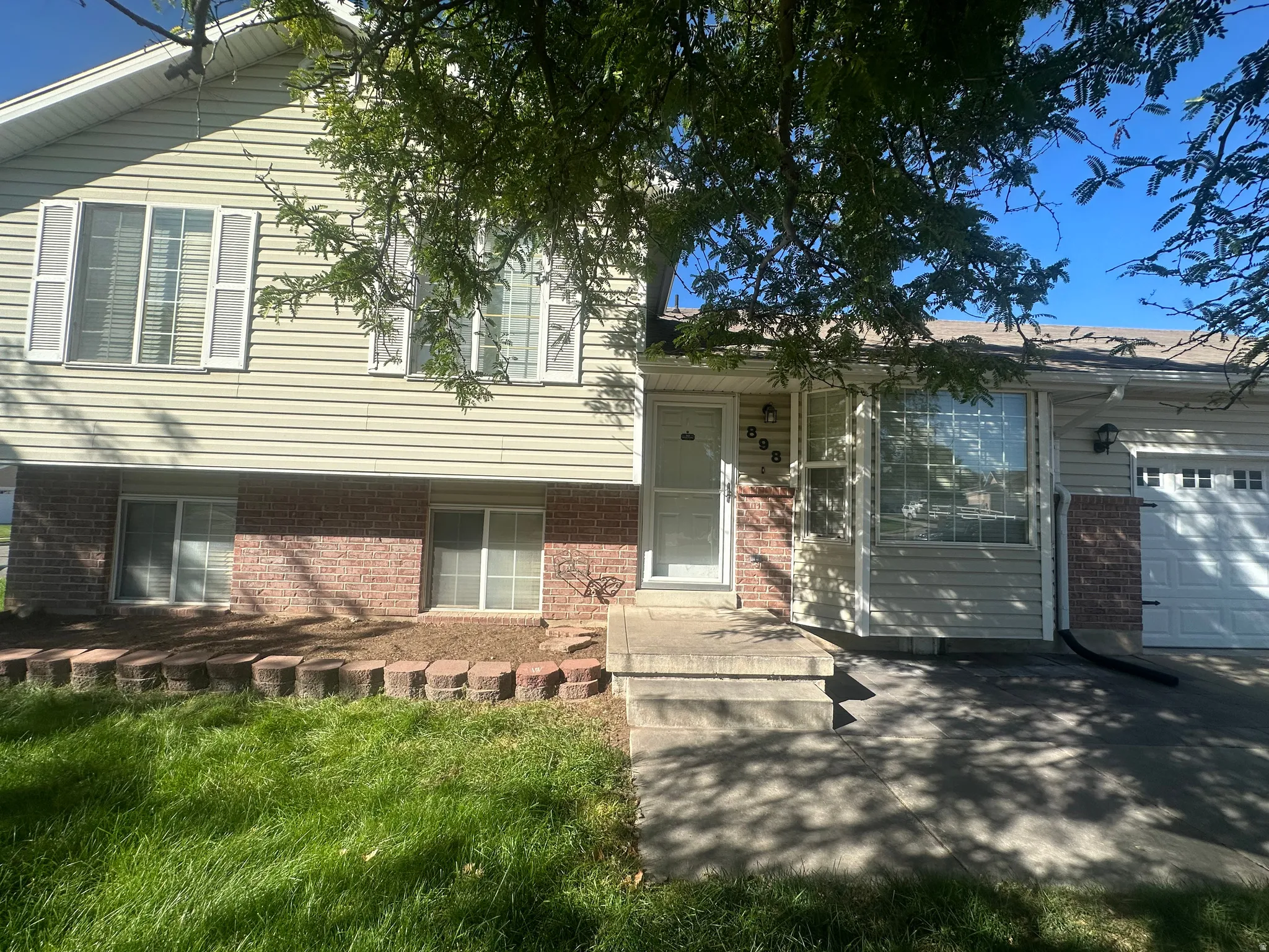 Split-level exterior featuring siding and brick accents
