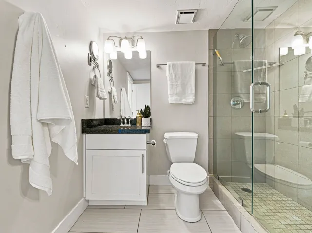 Walk-in shower with clear glass enclosure and tiled walls