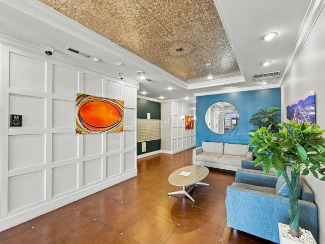 Recessed lighting, wood-finish flooring, accent wall with circular mirror, tray ceiling, and wainscoting paneling