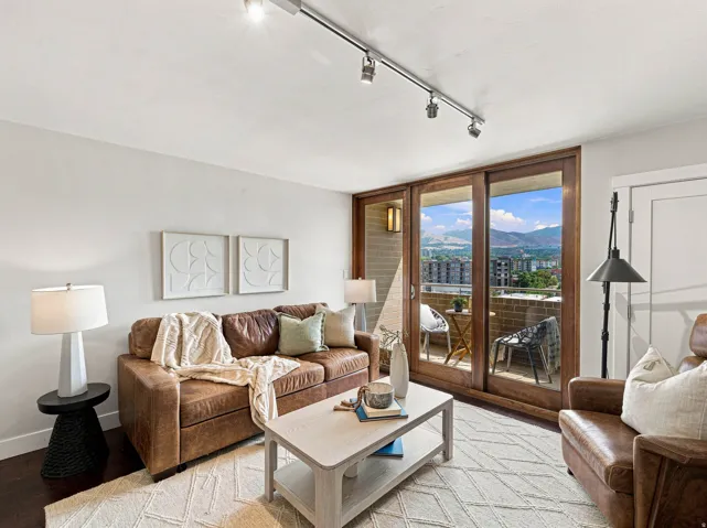 Spacious living area featuring wood-finish flooring, track lighting, and a full-width sliding glass door