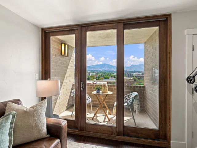 Sliding glass doors with wood-finish frames open to a private balcony