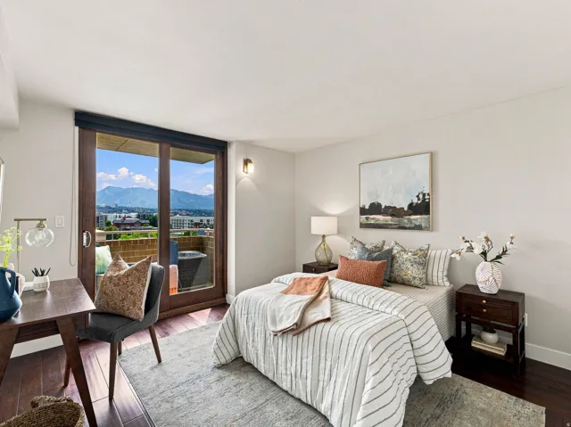 Hardwood flooring, wood-framed glass sliding door, mounted wall sconce, and a mountain backdrop