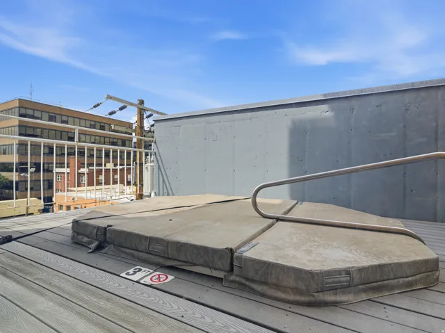 Outdoor spa with cover, composite decking, and metal railing