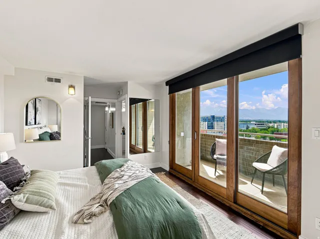 Hardwood-style flooring extends to the private balcony with a brick half-wall