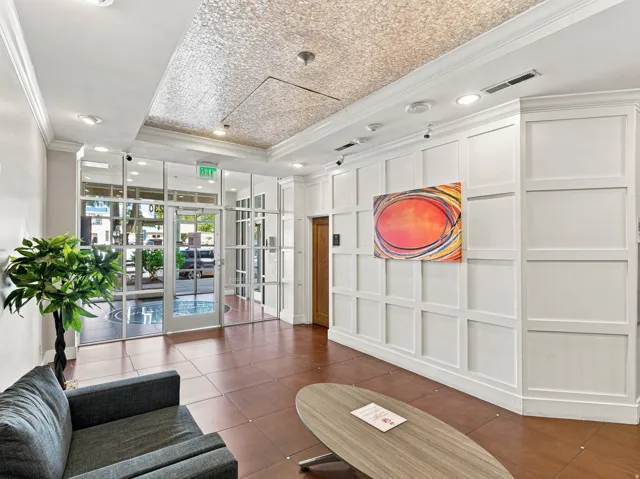 Tile flooring, recessed lighting, glass paneled entry, white paneled wall accents, and an ornate ceiling treatment