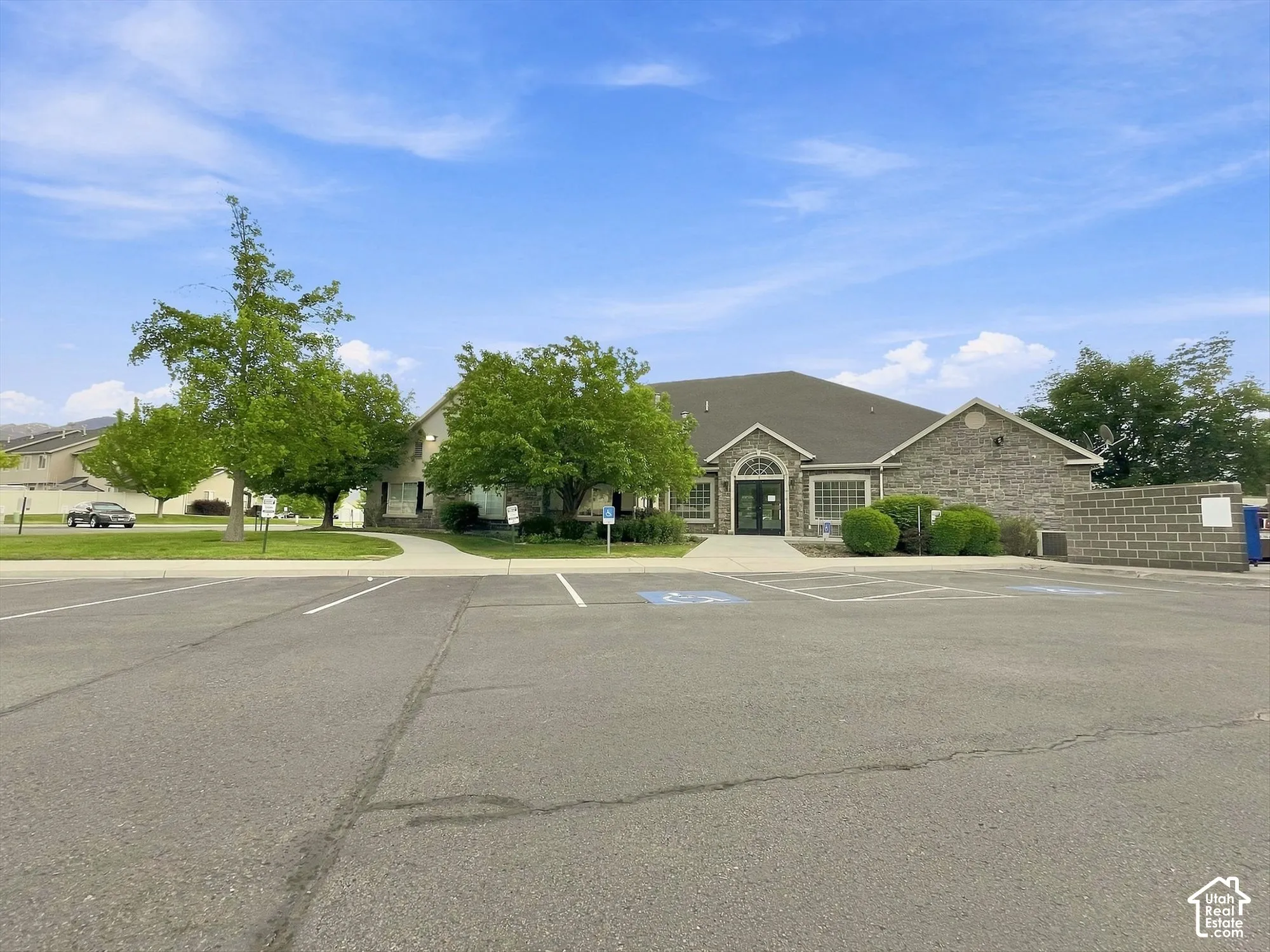 Stone facade building with an arched entry and expansive parking lot