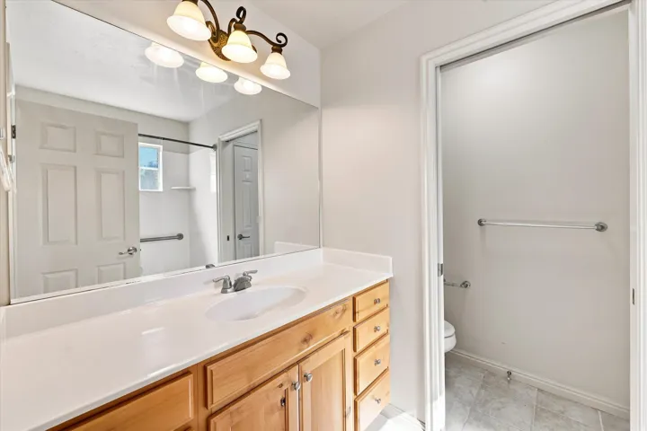 Light wood-finish vanity with a white countertop and integrated sink