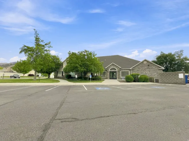 Stone facade building with an arched entry and expansive parking lot