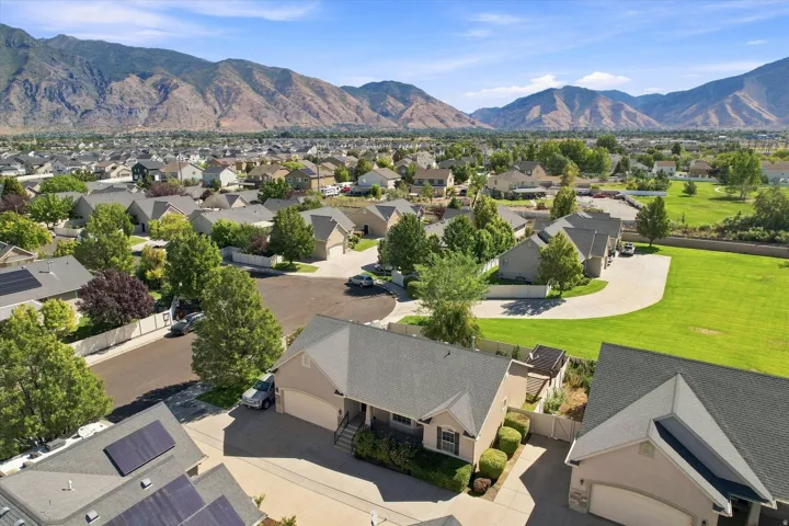 Residential neighborhood with a mountain backdrop, mature trees, and solar panels