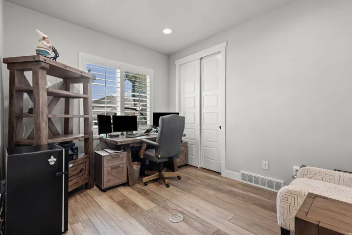 Room featuring wood-finish flooring, white baseboards, and light gray walls