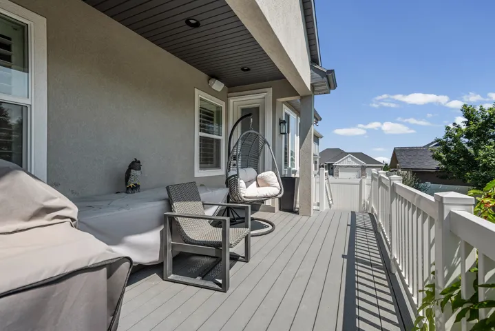 Outdoor deck featuring composite flooring, white railing, and stucco exterior