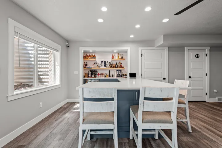 Entertainment space featuring a custom bar with open shelving and built-in cabinetry