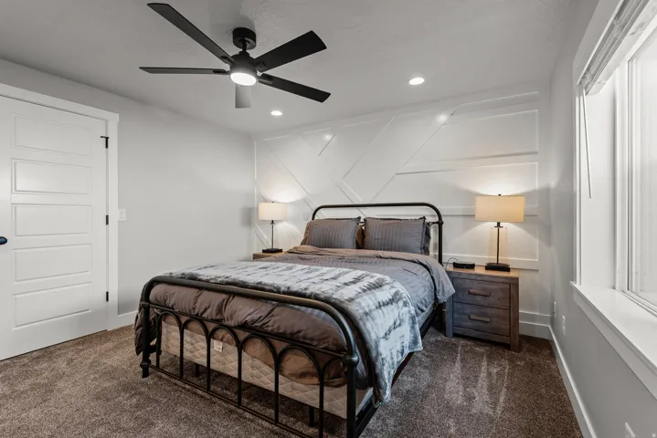 Accent wall with geometric paneling, recessed lighting, and a contemporary ceiling fan