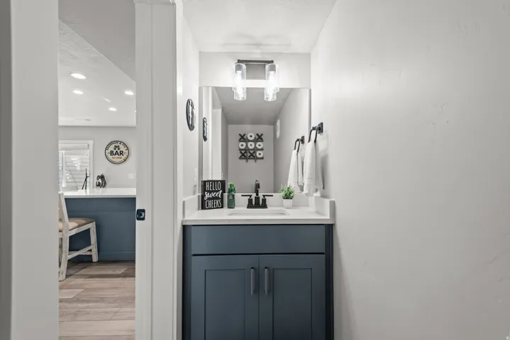 Bathroom featuring a vanity with a white countertop, undermount sink, and dark blue cabinetry