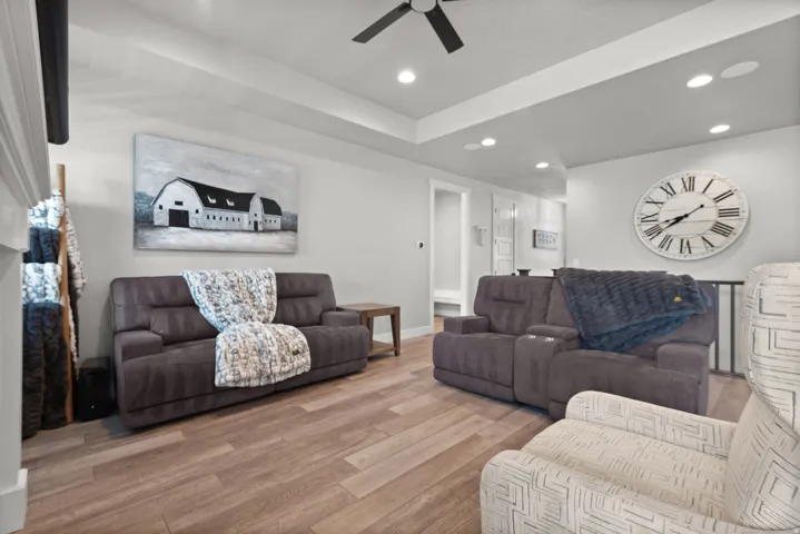 Spacious living area featuring wood-finish flooring, recessed lighting, and a tray ceiling