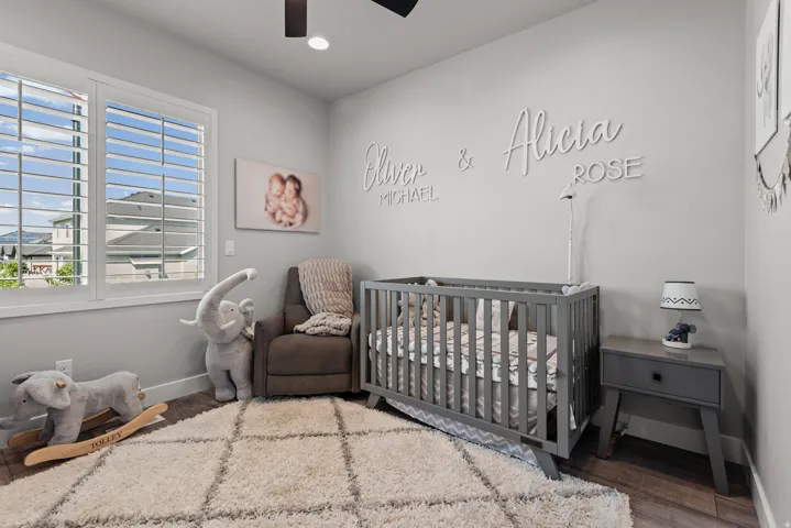 Room featuring a large window with white plantation shutters, dark wood-finish flooring, and light-toned walls