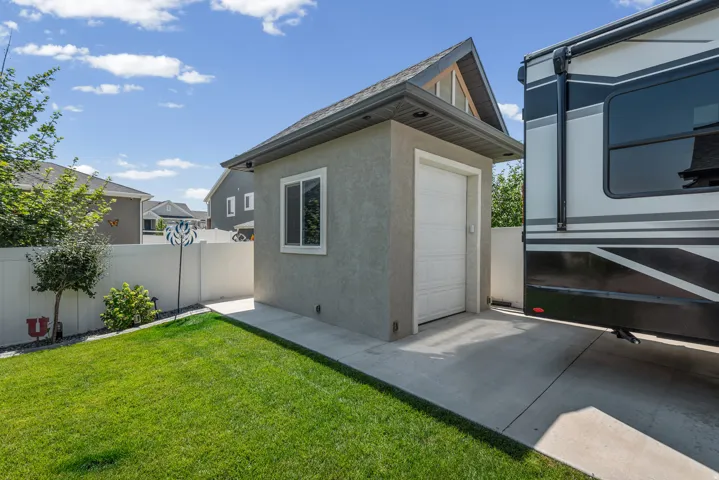 Detached garage structure featuring a stucco exterior, white garage door, and a single window