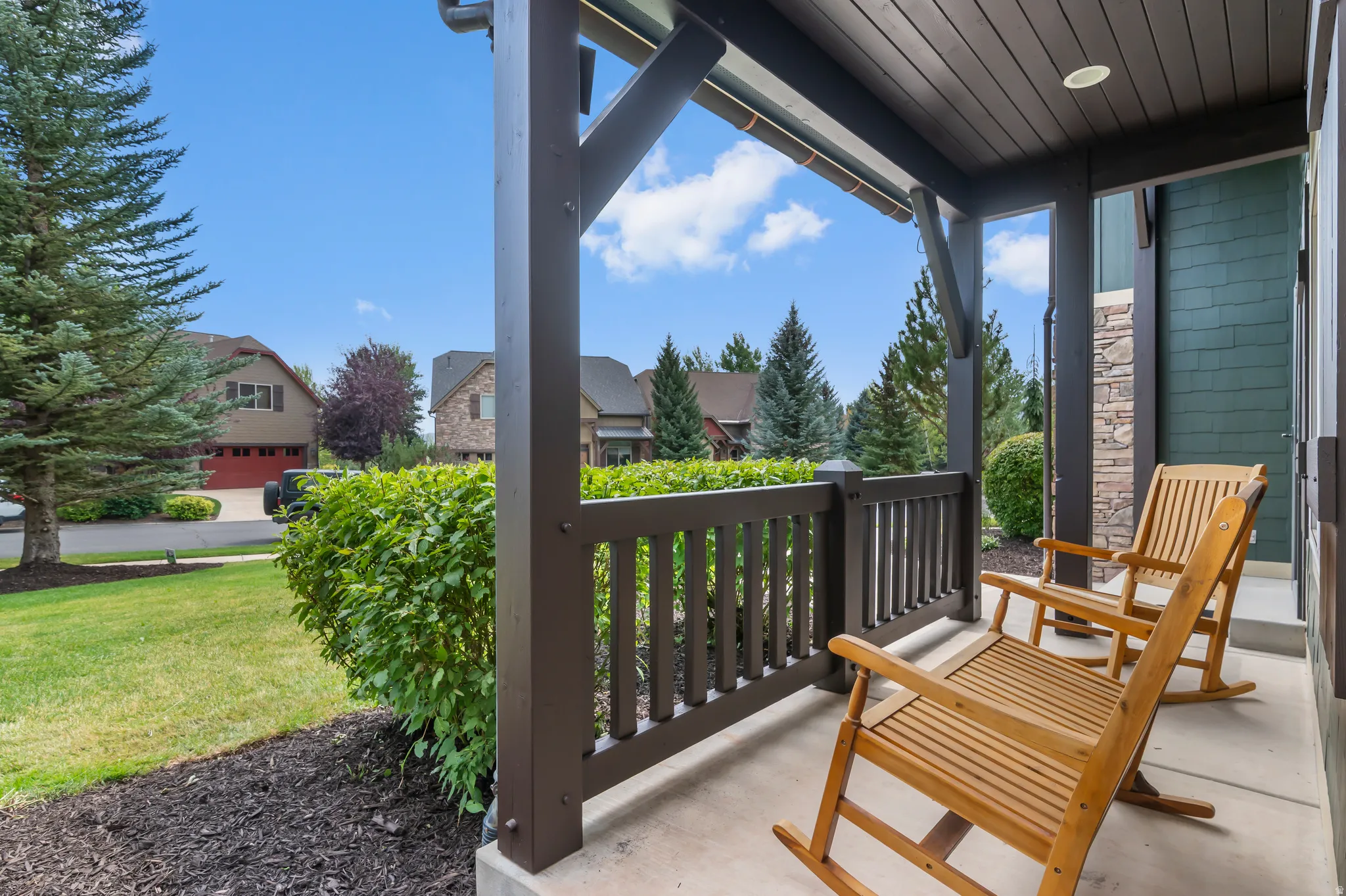 Covered front porch with dark wood-finish posts and railing