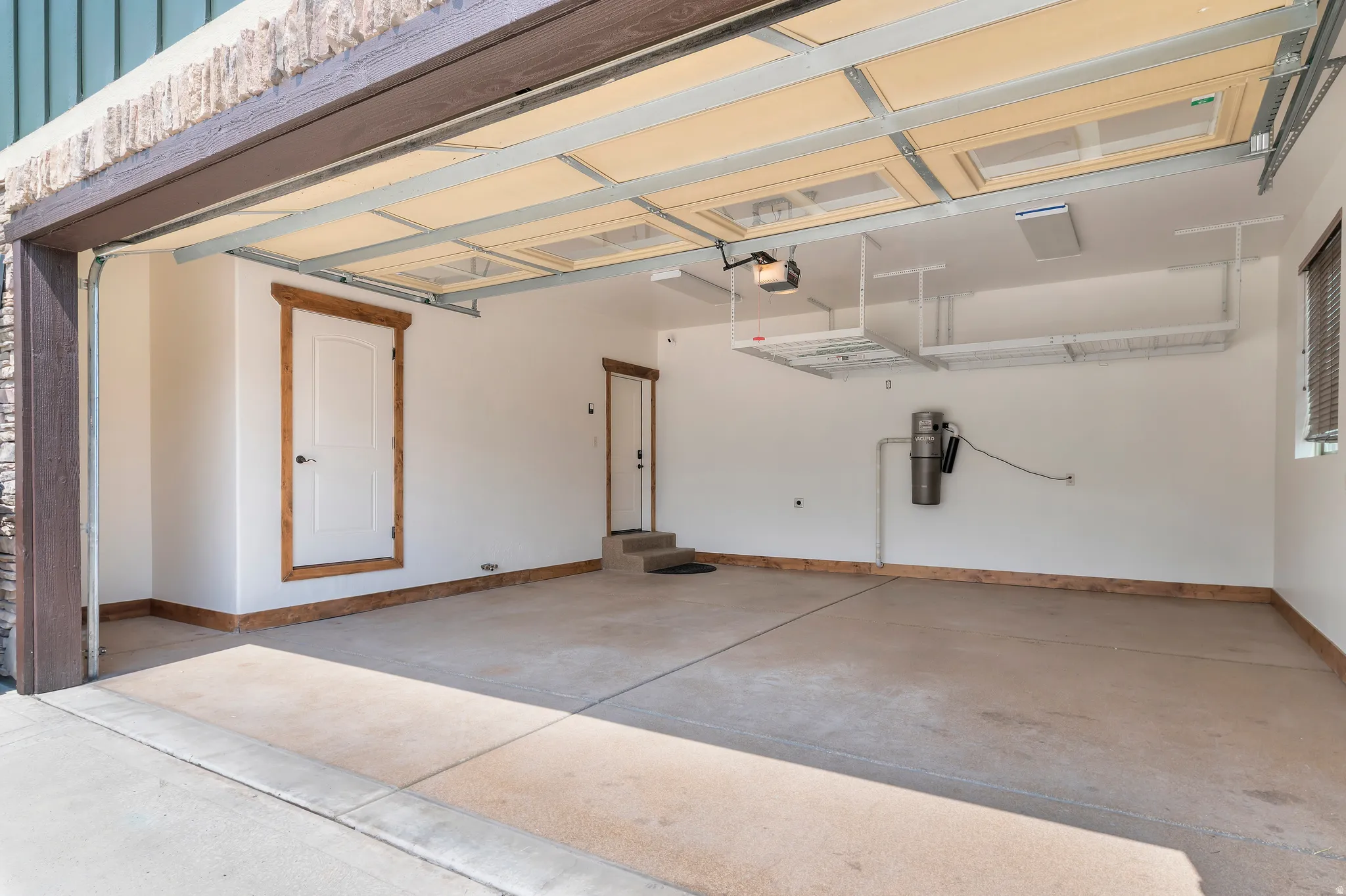 Attached garage with overhead storage, a built-in vacuum system, and two interior access doors