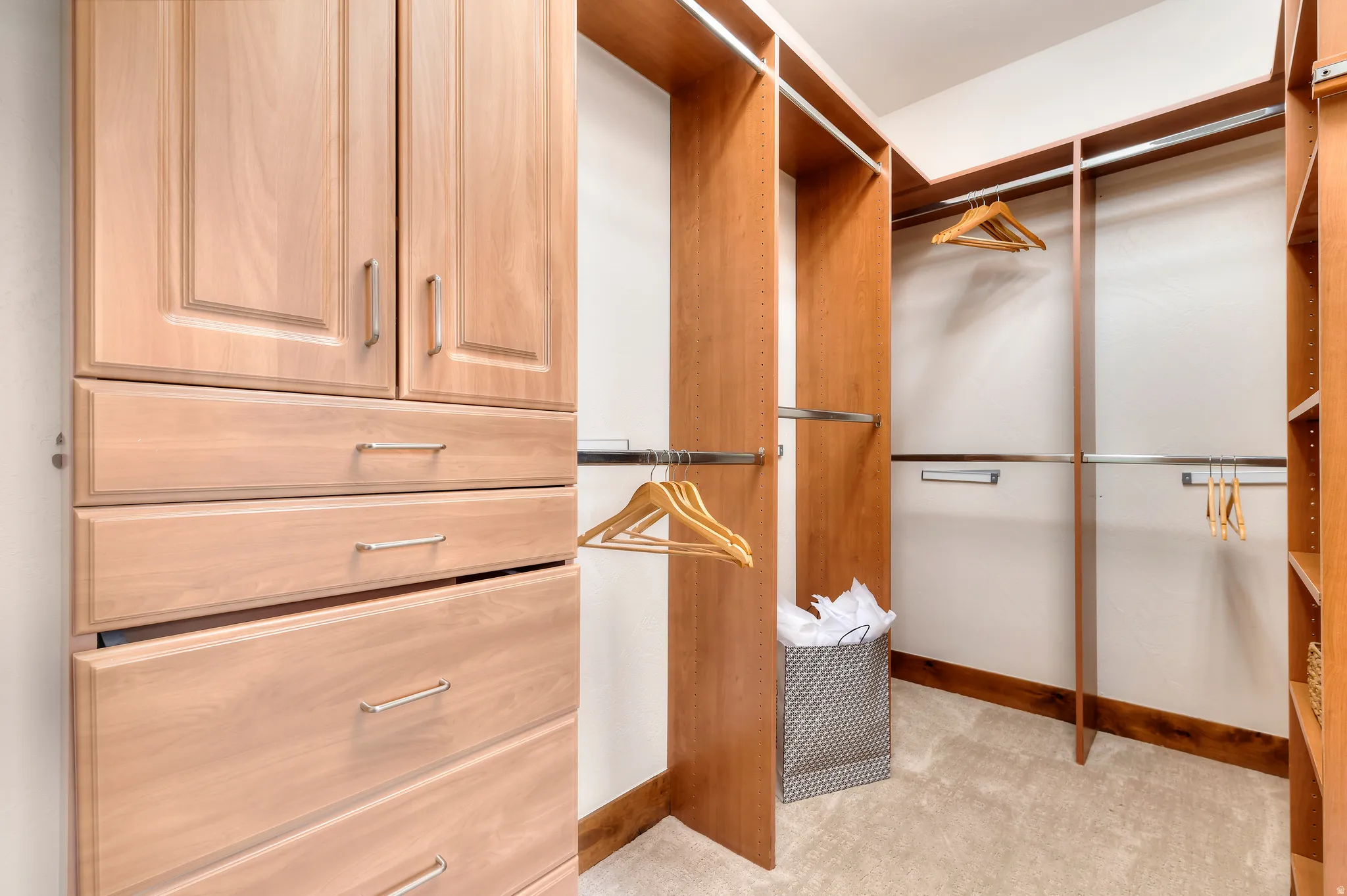 Built-in closet system with varied storage, multiple hanging rods, shelving, and drawer storage
