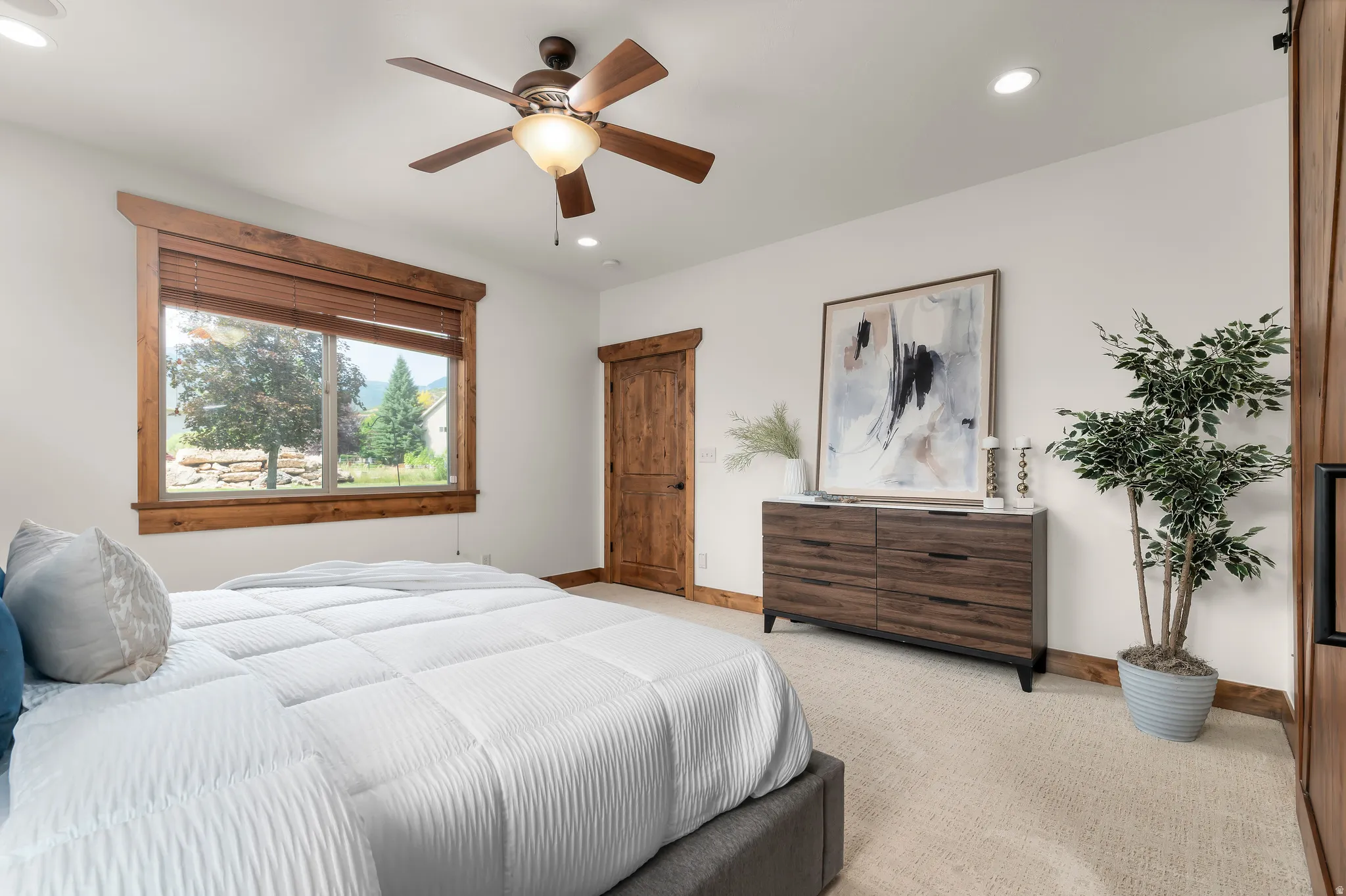 Recessed lighting, wood-finish ceiling fan, wood-finish window trim, wood-finish interior door, and carpet flooring