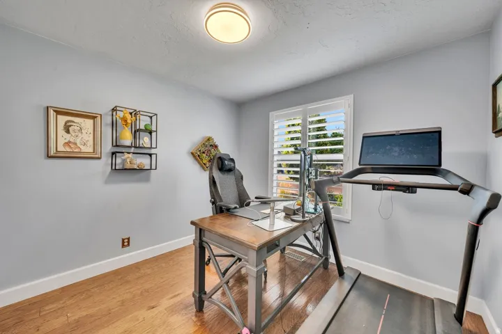 Hardwood-finish flooring, light grey wall paint, and white window shutters